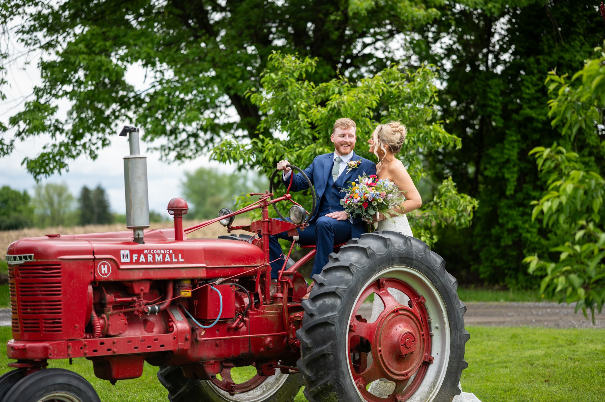 Bride and groom on tractor at Cobblestone Wedding Barn in Scottsville, NY | Rochester Wedding Photography